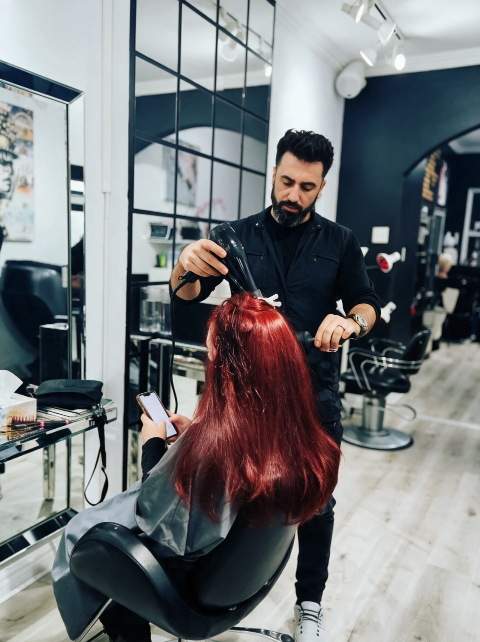 Pezh blow-drying a client's red hair in his studio